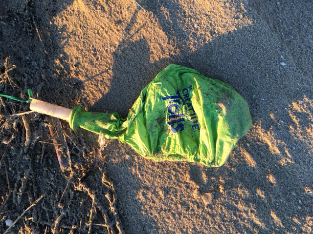 Ballonrestjes en lintjes op het strand